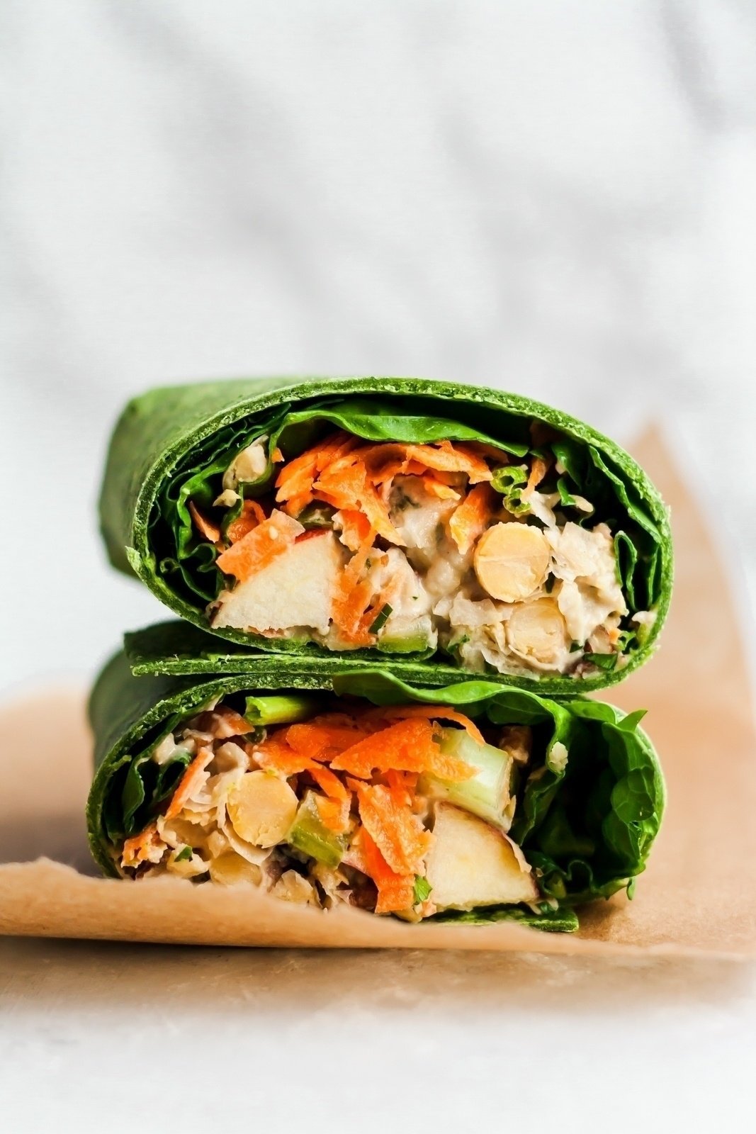 vegan apple chickpea salad in wraps stacked on top of eachother