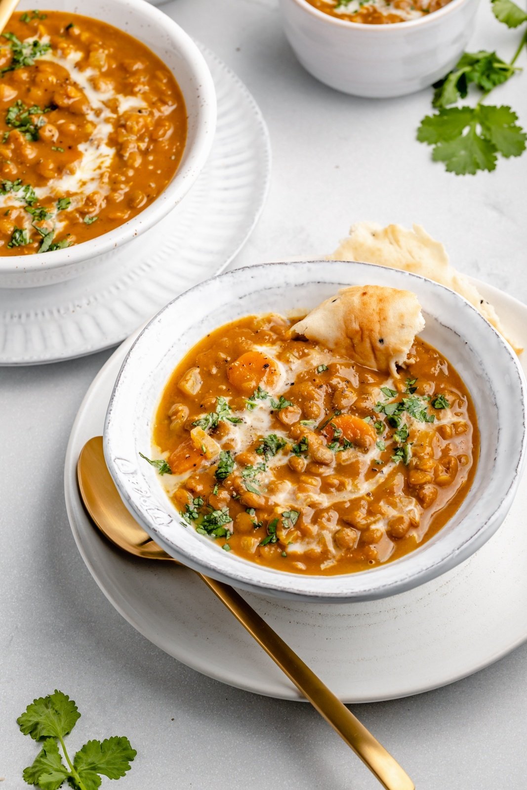 vegan pumpkin lentil soup in a bowl with pita bread