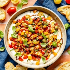 whipped feta bruschetta dip in a bowl next to crostini