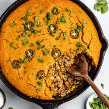 white chicken chili pie with pumpkin cornbread crust in a skillet