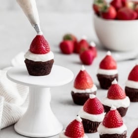 piping frosting onto santa hat brownies