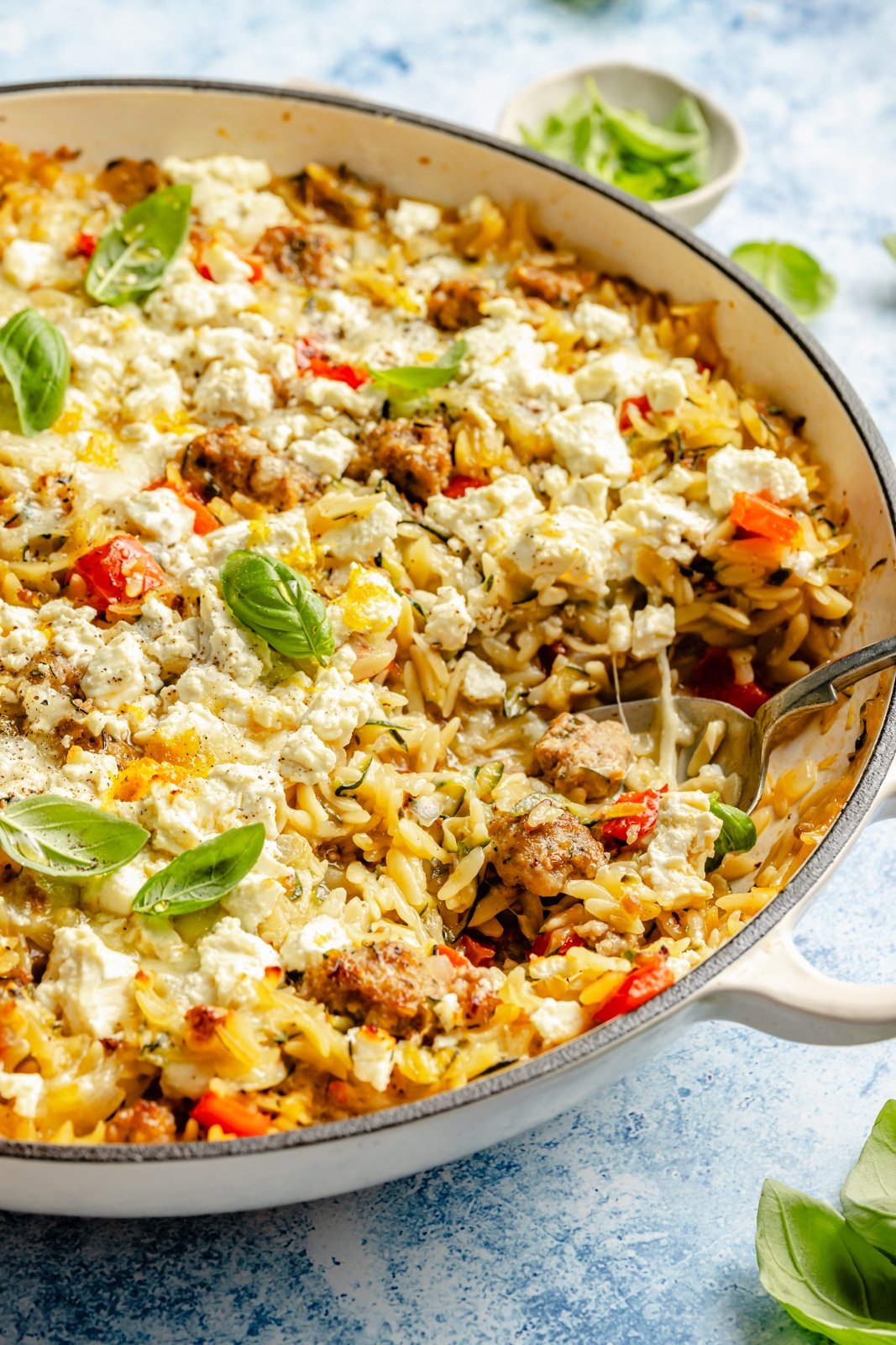 cheesy zucchini sausage orzo bake in a skillet